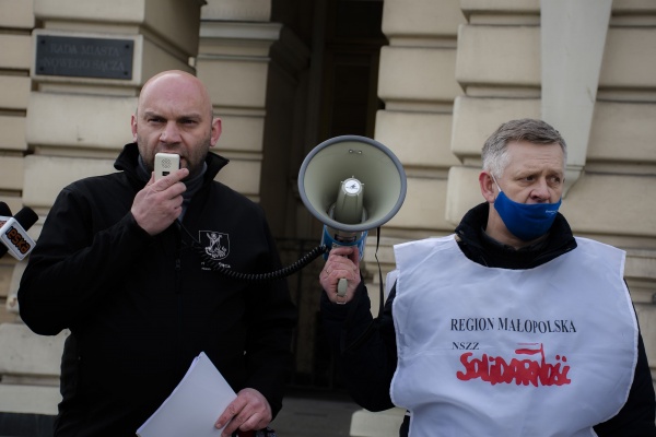 zastępca prezydenta Artur Bochenek przemawia a  kierownik oddziału NSZZ Solidarność w Nowym Sączu Krzysztof Kotowicz trzyma megafon