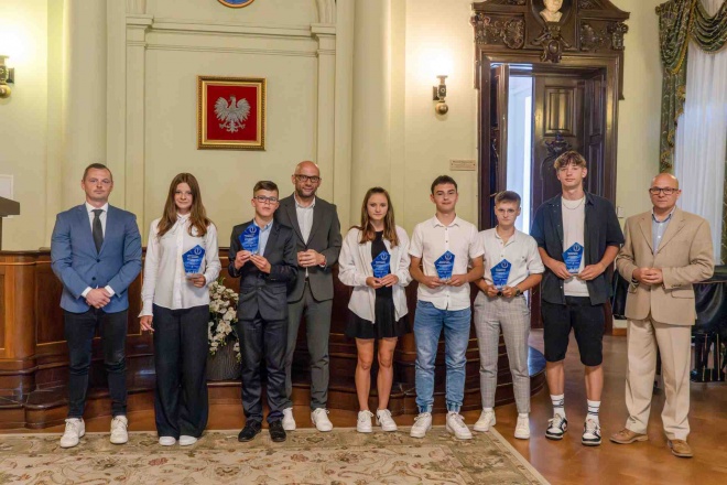 Radny Dawid Dumana, Artur Bochenek, zastępca prezydenta miasta i Tomasz Baliczek, zastępca dyrektora Wydziału Kultury i Sportu z nagrodzonymi uczniami