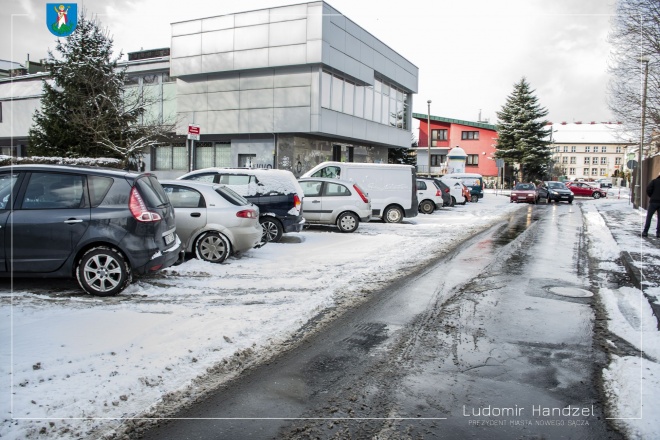 Zdjęcie przedstawiające nowo wybudowany parking. W tle zaśnieżonego podjazdu stoją zaparkowane samochody.