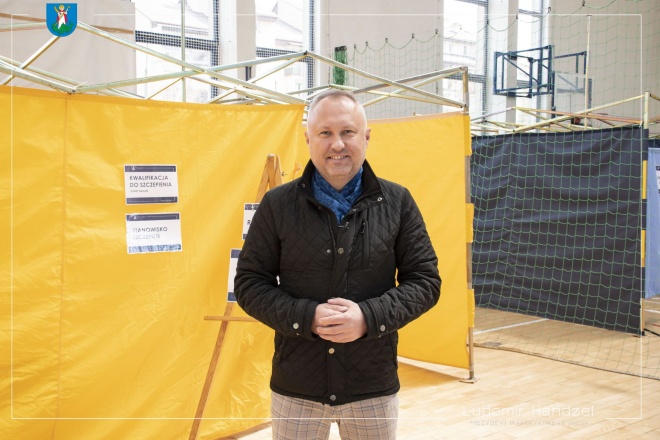 Prezydent Ludomir Handzel na tle punktu szczepień. 